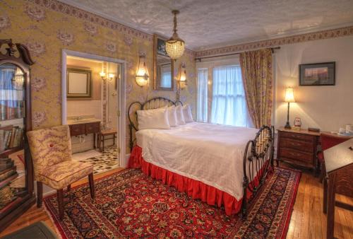 a bedroom with a bed and a desk and a chair at Bluefield Inn, a Select Registry Propery in Bluefield