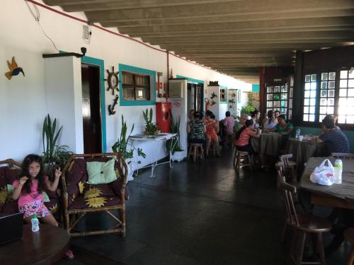 een groep mensen die aan tafel zitten in een restaurant bij Pousada Costa Verde in Caraguatatuba
