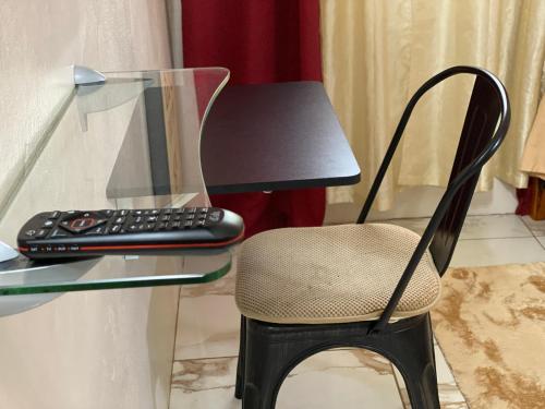 - un bureau en verre avec une chaise et une télécommande dans l'établissement More Than Beauty Properties, à Road Town