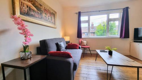 a living room with a couch and a table at Richmond Modern Apartment in Richmond upon Thames