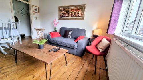 a living room with a couch and two chairs and a table at Richmond Modern Apartment in Richmond upon Thames
