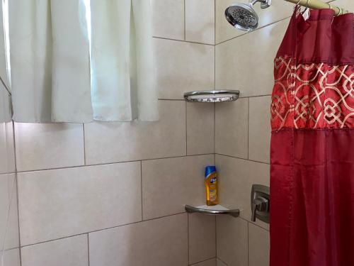 a shower with a red shower curtain next to a red shower curtainuggest at More Than Beauty Properties in Road Town