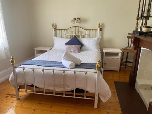 a bedroom with a bed with white sheets and pillows at Harbour Master's Cottage in Stanley
