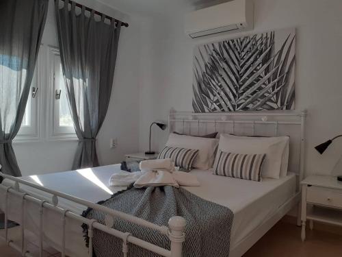 a bedroom with a white bed with a headboard at Villa Tillia in Panormos Skopelos