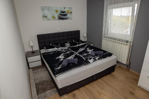 a bedroom with a bed with a black and white comforter at Kuća za odmor Martin in Sveti Martin na Muri