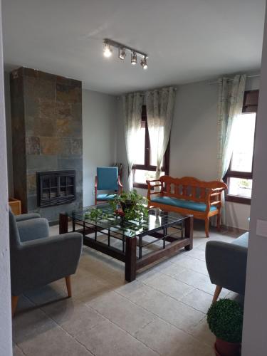 uma sala de estar com uma mesa de centro e uma lareira em Hotel Alma Rosa em Navaluenga
