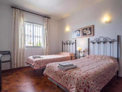 a bedroom with two beds and a window at Villa Azahara in Nerja
