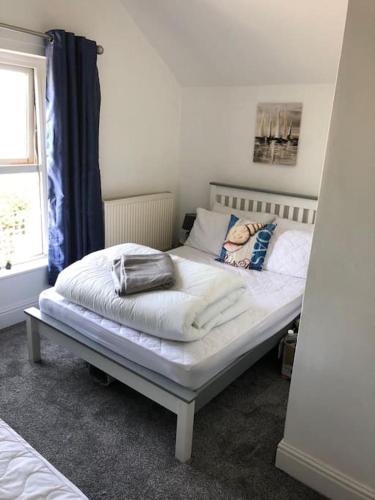 a white bed in a room with a window at Newly renovated 1st floor apartment with mountain views in Tywyn