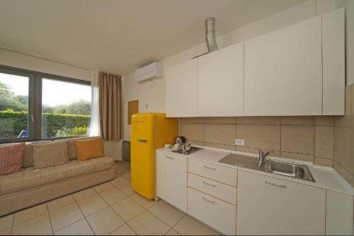una cucina con lavandino e un divano in una camera di Residence Arca a Bardolino