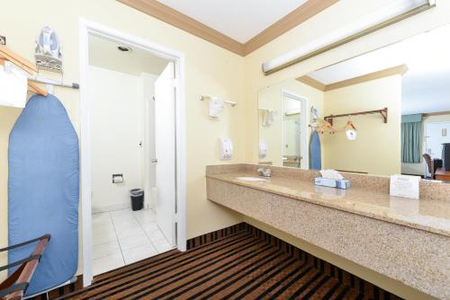 La salle de bains est pourvue de 2 lavabos et d'un grand miroir. dans l'établissement Americas Best Value Inn Vacaville, à Vacaville