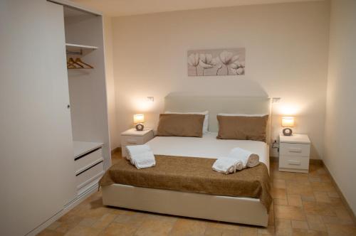 a white bedroom with a bed and two night stands at Cann'e Sisa Luxury Villa Perla Marina A in Torre delle Stelle