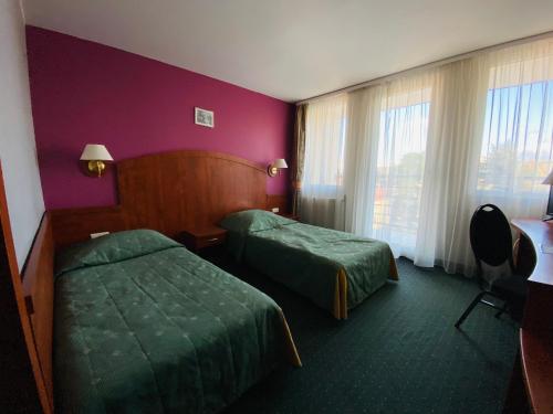 Habitación de hotel con 2 camas y ventana en Hotel Pietrak, en Trzemeszno