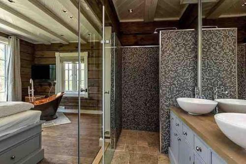 a bathroom with two sinks and a shower at Stor og eksklusiv tømmerhytte Hemsedal in Grøndalen