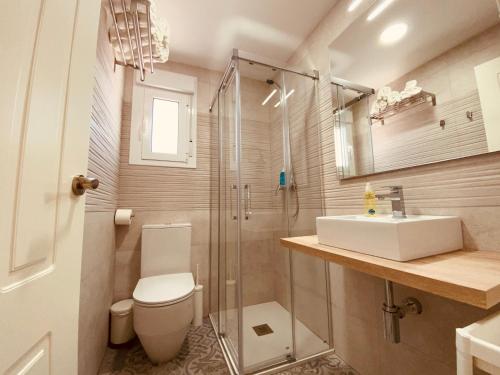 ein Bad mit einem WC, einem Waschbecken und einer Dusche in der Unterkunft Summerlandrota Argüelles 4 in Rota