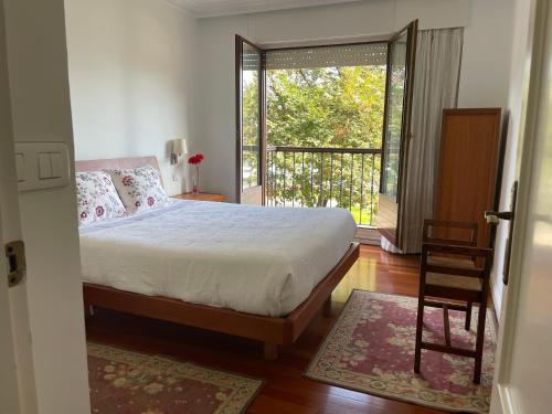 1 dormitorio con 1 cama y balcón en RIVER SUITE Apartment, en Portugalete