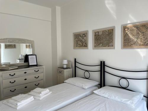 een slaapkamer met 2 bedden en een dressoir met een spiegel bij Casa Gelindo - large and fine apartment with two bathrooms in Sestri Levante