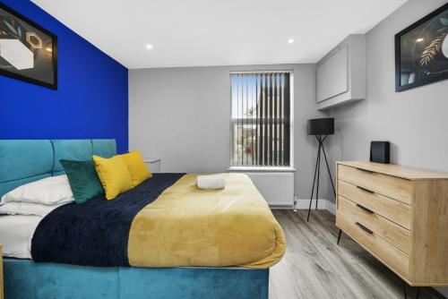 a bedroom with a blue bed and a wooden dresser at Stuning Central Oxford 2 Bedroom Flats Free WiFi in Oxford