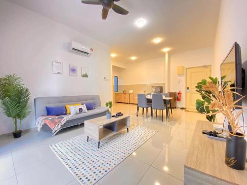 uma sala de estar com um sofá e uma mesa em Atlantis Residences Melaka by HeyStay Management em Malaca