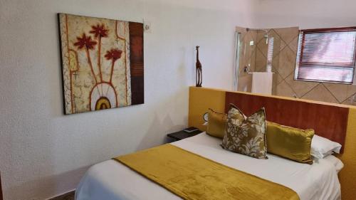 a bedroom with a bed with a yellow blanket on it at St Michelle Guest Lodge & Hydro Retreat in Alberton