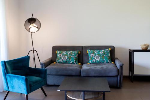 un salon avec un canapé et une chaise dans l'établissement Domaine d'Arca Porto Vecchio - T2 - Rez de Jardin - 4 personnes 