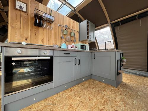 a kitchen with a stove top oven in a garage at Moonlight Dome Tent in Tenby