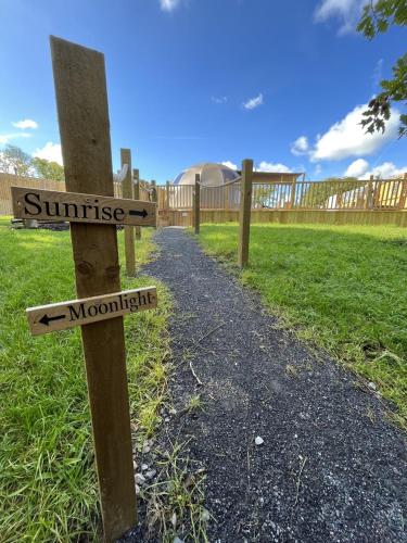 a sign that says sunrise and moonrise on a path at Moonlight Dome Tent in Tenby
