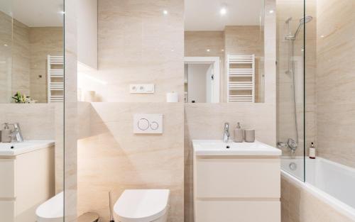a bathroom with a toilet and a sink and a shower at Piedmont Home 2 by LoftAffair in Krakow