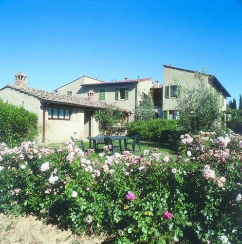 a house with a garden with flowers in front of it at Podere Il Pino in Poggibonsi