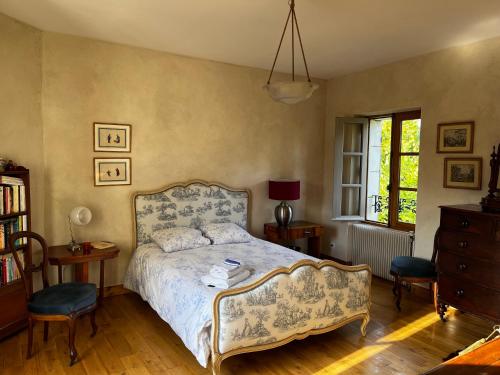 1 dormitorio con 1 cama, 2 sillas y ventana en Chambres d'hôtes Place Balanant, en Buzançais