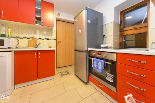 cocina grande con armarios rojos y nevera en Apartment in Sarajevo, en Sarajevo