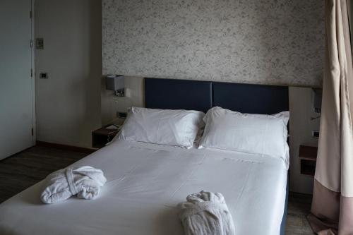 a bedroom with a white bed with towels on it at Splendid Hotel Taormina in Taormina