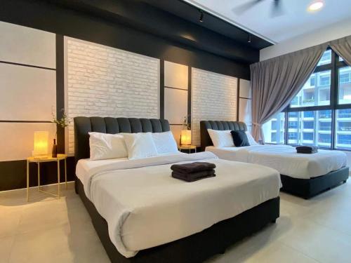 a bedroom with two beds and a large window at Atlantis Residences Melaka by HeyStay Management in Melaka