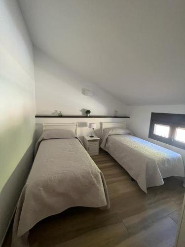 een slaapkamer met 2 bedden en een raam bij Casa rural huertas largas in Casarabonela