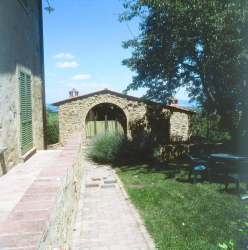 a stone building with a table and chairs in a yard at Podere Il Pino in Poggibonsi