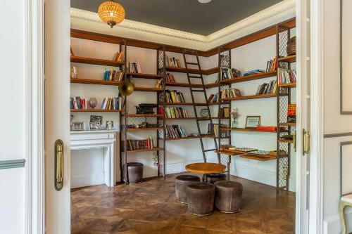 a room with book shelves and a table and a stool at Casa Gracia in Barcelona