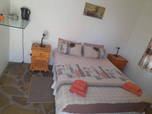 una camera da letto con un letto con due asciugamani rossi di Ombo Rest Camp a Okahandja