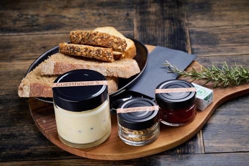 a wooden plate with two jars of jam and bread at Guesthouse S in Luče
