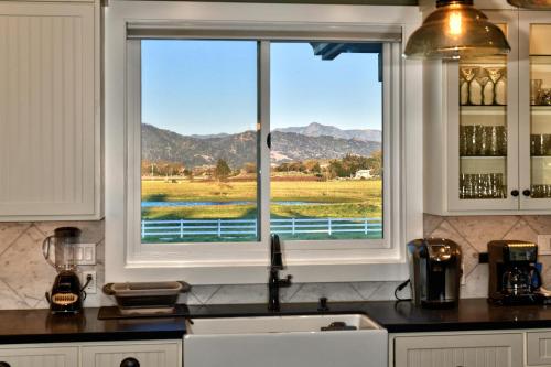 a kitchen with a window with a view of the mountains at Sanctuary On Lytton A Wine Country Escape in Geyserville
