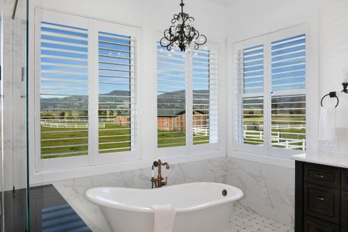 baño con bañera blanca y ventanas en The Sanctuary on Lytton, en Geyserville