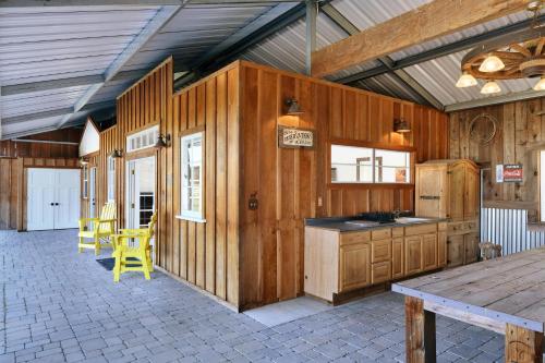 a kitchen with wooden walls and a table and yellow chairs at Sanctuary On Lytton A Wine Country Escape in Geyserville