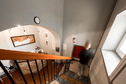 a woman walking down a staircase in a room at Casa De Wawa in Warsaw