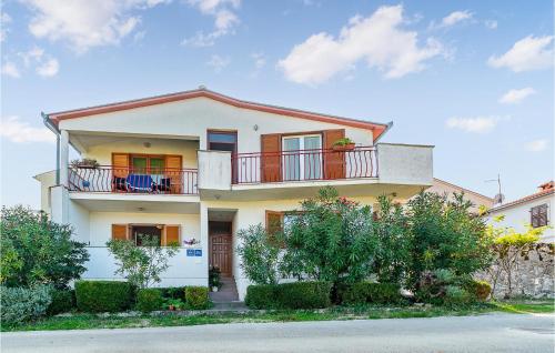 a white house with a balcony on a street at Apartmen Valkanela Vi in Vrsar