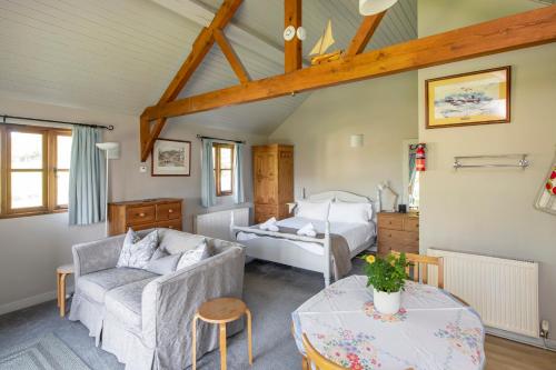 ein Wohnzimmer mit einem Bett, einem Sofa und einem Tisch in der Unterkunft Beautiful Cottage With Stunning Views in Box in Box