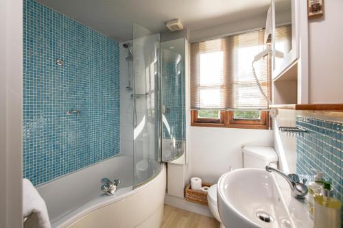 W łazience znajduje się prysznic, wanna i umywalka. w obiekcie Beautiful Cottage With Stunning Views in Box w mieście Box