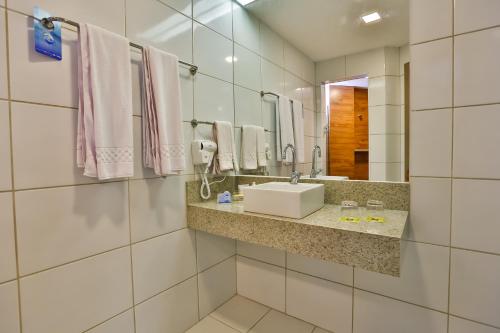 a bathroom with a sink and a mirror at ARCUS Hotel By Atlântica in Aracaju
