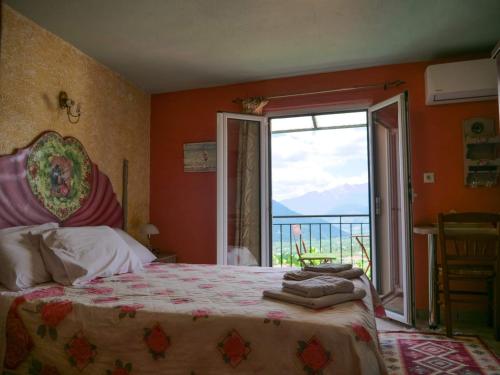 a bedroom with a bed and a large window at Η Φωλιτσα in Karpenisi