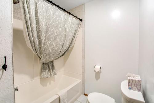 a white bathroom with a tub and a toilet at St Claires Halo in Olympia