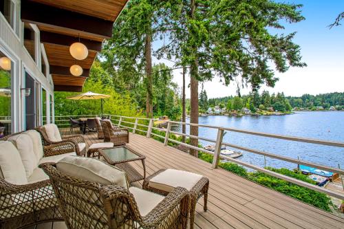 a porch with wicker chairs and tables on a lake at St Claires Halo in Olympia