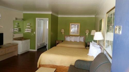 a hotel room with a bed and green walls at Kelseyville Motel in Kelseyville