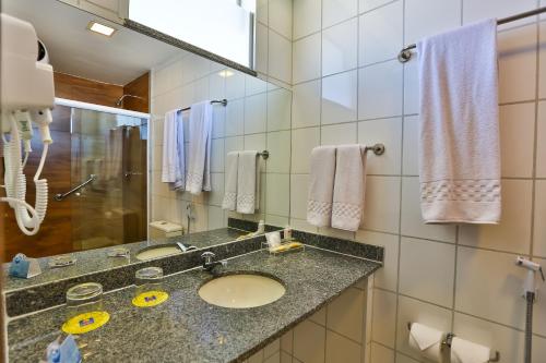 a bathroom with a sink and a mirror at ARCUS Hotel By Atlântica in Aracaju